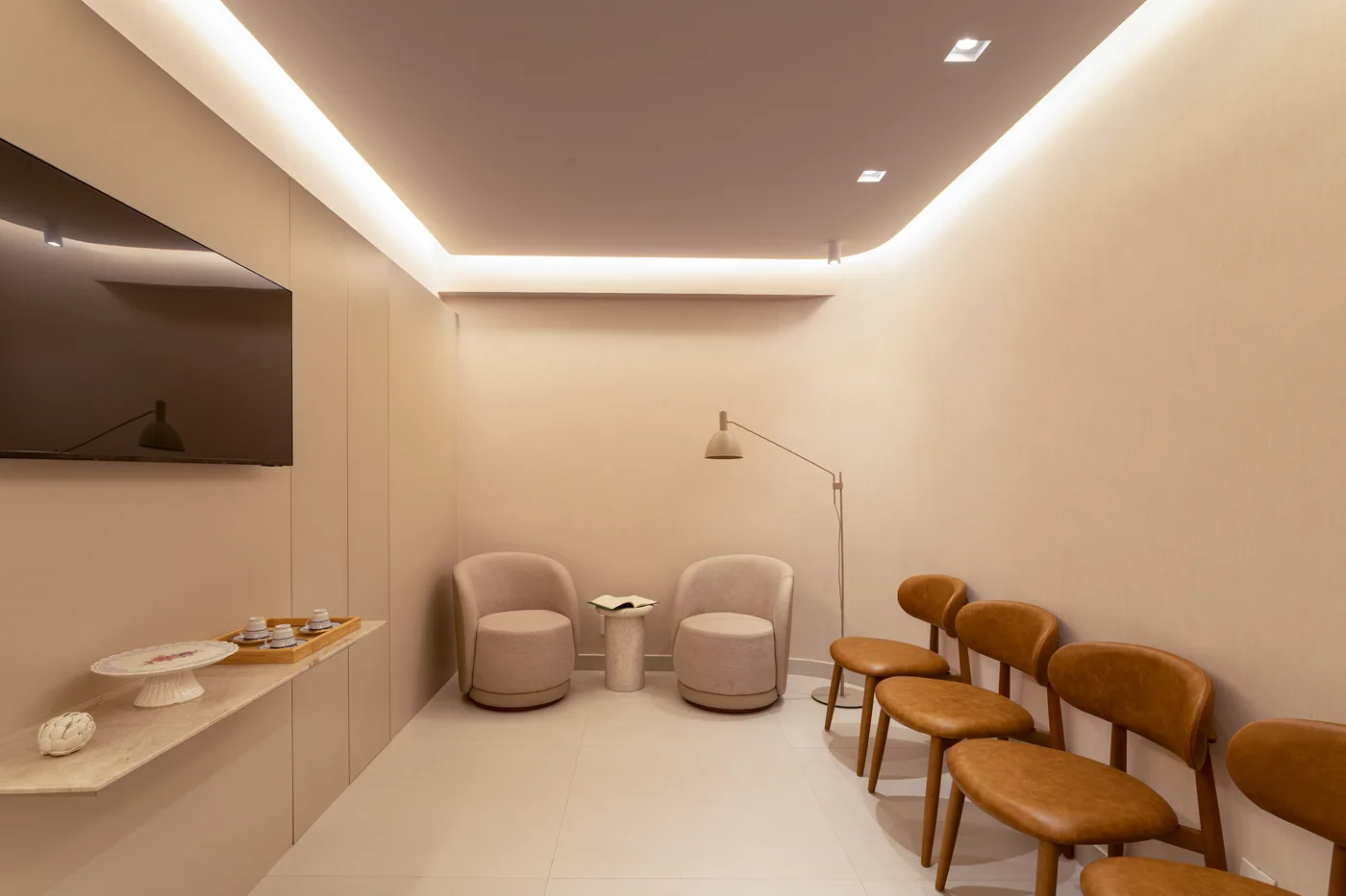 Recepção do consultório com poltronas e iluminação acolhedora