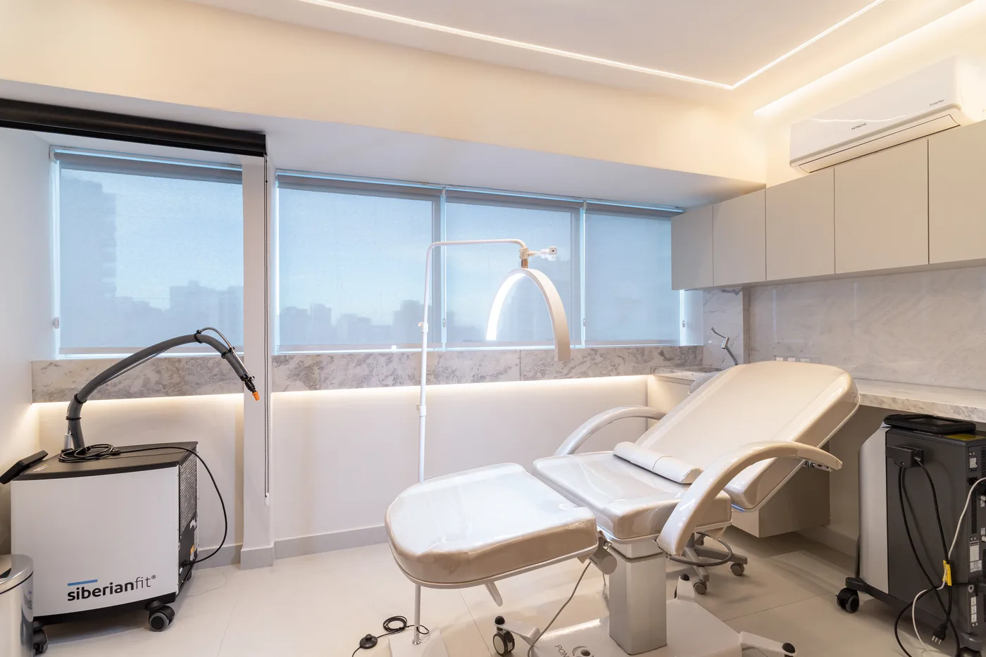 Sala de procedimentos com maca e vista da cidade