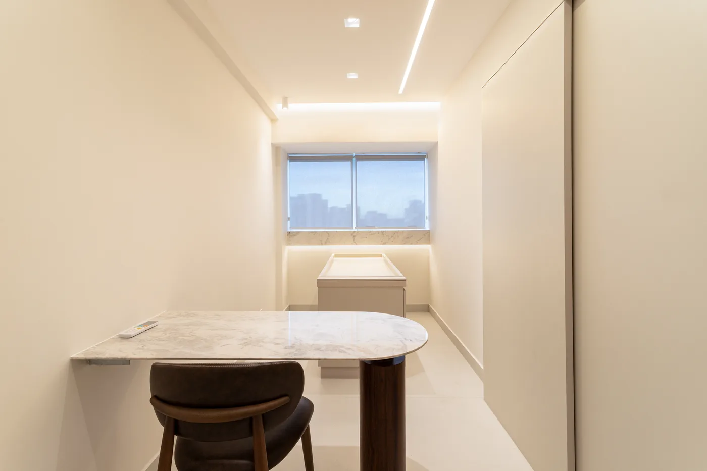 Sala de consulta com mesa de mármore e janela