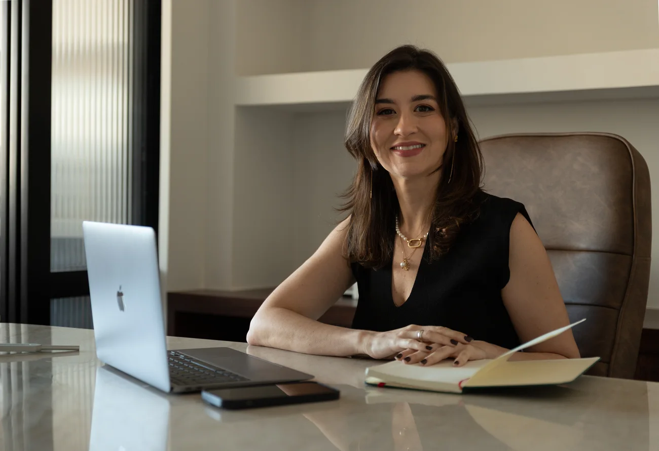 Dra. Laila Reggiani à mesa de trabalho no consultório